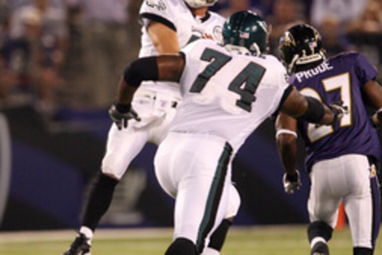 Eagles' Kevin Kolb fires pass with Winston Justice trying to block rushing Raven Ronnie Prude.