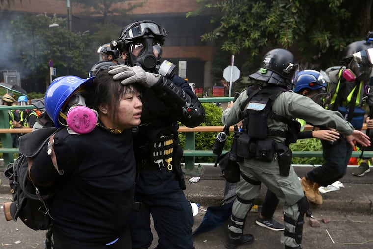 In this Nov. 18 file photo, riot police detain protesters at Hong Kong Polytechnic University in Hong Kong. Police ended their blockade of the campus Friday after sweeping it for dangerous items following a two-week violent standoff with demonstrators.