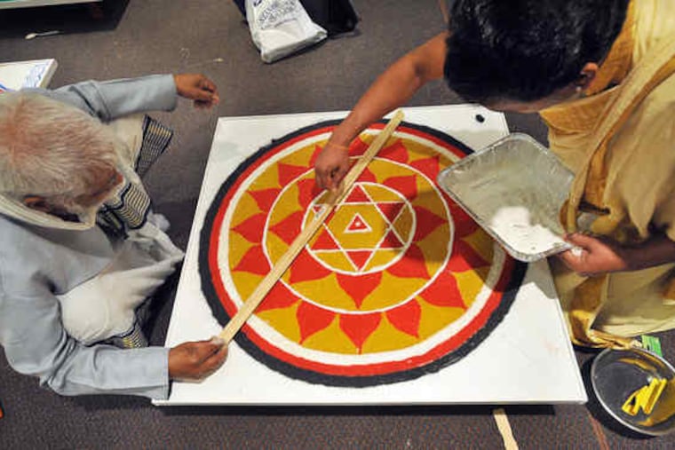 In the cultural center of the new Bharatiya Temple in Chalfont, priests from across the country and India create a yantra of colored rice, readying for Prana Pratishtha Mahotsava ceremony.