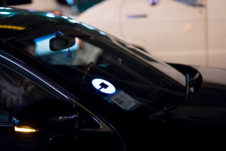 An Uber logo on a windshield in Los Angeles, Calif.