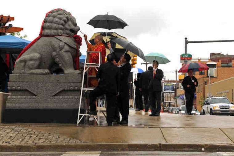 Buddhist monk Thich Truyen Nhu of Temple Chua Quan Am at 12th Street and Ridge Avenue blesses the Foo Dog statues - Chinese guardian lions - before dedication ceremonies Wednesday of the renovated 10th Street Plaza at 10th and Vine Streets in Chinatown. Story and photos on B2.