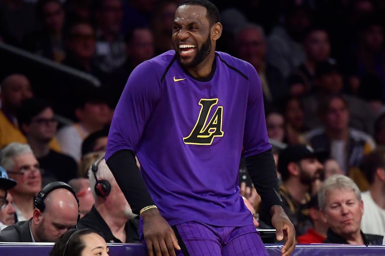 Los Angeles Lakers forward LeBron James laughs as he waits to check in to the team's NBA basketball game against the Charlotte Hornets during the second half Friday, March 29, 2019, in Los Angeles. The Lakers won 129-115.