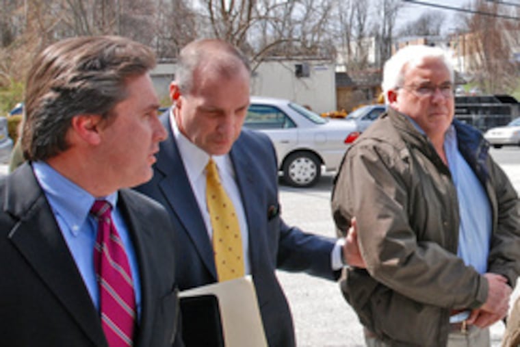 Haverford Township Commissioner Fred Charles Moran (right) surrenders after a grand jury filed bribery charges against him. He is accused of asking a developer to pay $500,000 to win needed approvals.