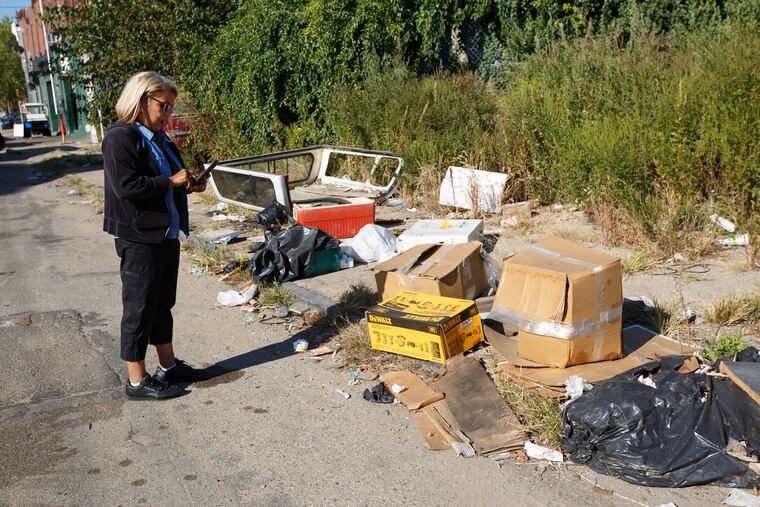 Clean block officer Diane Oliveras inspects the 2400 block of West Sedgely Street in North Philadelphia, as she conducts an indexing to determine where loose litter and illegal dumping is the worst, Tuesday, Oct. 3, 2017.