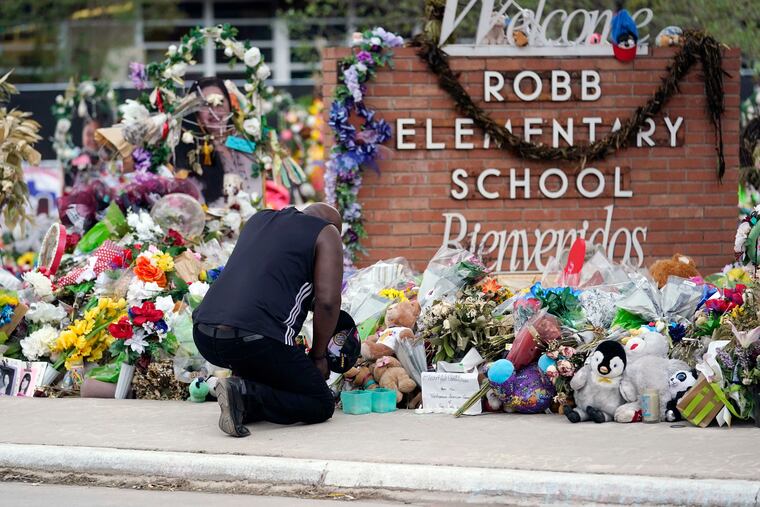 Reggie Daniels pays his respects at a memorial at Robb Elementary School, June 9, 2022, in Uvalde, Texas. A criminal investigation in Texas over the hesitant police response to the Robb Elementary School shooting remains ongoing a year after a gunman killed 19 children and two teachers in Uvalde.