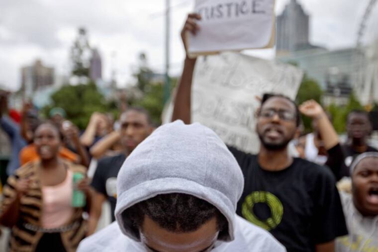A demonstrator wears a hoodie during a protest the day after George Zimmerman was found not guilty in the 2012 shooting death of teenager Trayvon Martin, Sunday, July 14, 2013, in Atlanta. (AP Photo/David Goldman)