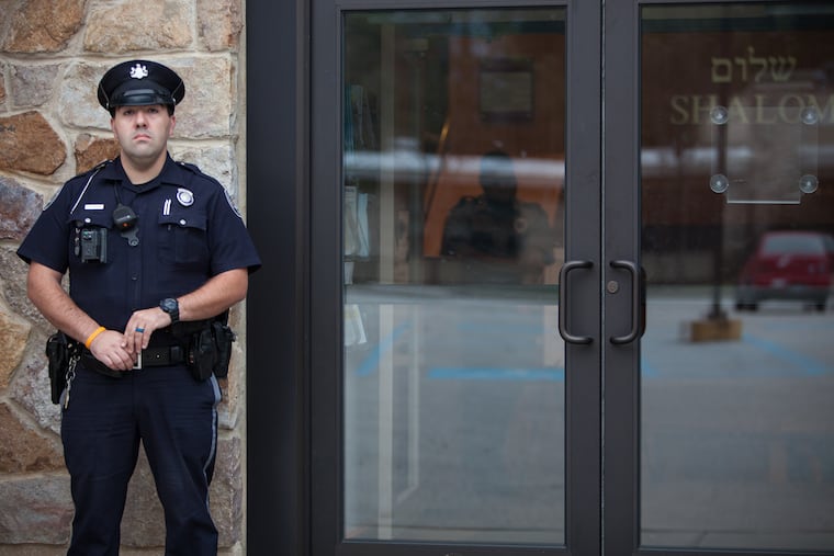 Officer Dan Gilbert stands guard out front of Beth David Reform Congregation.