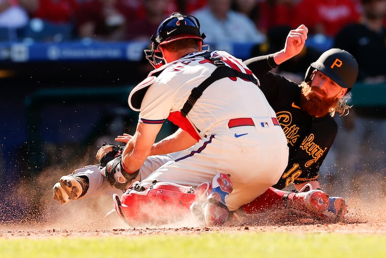 Phillies catcher J.T. Realmuto tugs out the Pirates' Colin Moran at home during the seventh inning on Sunday.