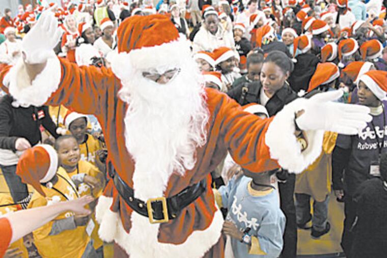 Santa Claus greets children during a Christmas party for children from North Philadelphia at Girard College on Saturday afternoon. (Laurence Kesterson / Staff Photographer)