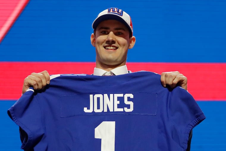 Duke quarterback Daniel Jones poses with his new jersey after the New York Giants selected Jones in the first round at the NFL football draft, Thursday, April 25, 2019, in Nashville, Tenn. (AP Photo/Mark Humphrey)