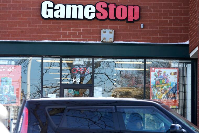 A vehicle passes in front of a GameStop store in Vernon Hills, Ill., Thursday, Jan. 28, 2021. The online trading platform Robinhood is moving to restrict trading in GameStop and other stocks that have soared recently due to rabid buying by smaller investors. GameStop stock has rocketed from below $20 earlier this month to close around $350 Wednesday as a volunteer army of investors on social media challenged big institutions who had placed market bets that the stock would fall.
