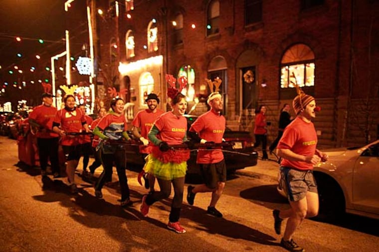 Pulling a sleigh, Dave Mavier, 25 as Rudolph leads, Christina George, William Campbell, Carolyn Redmond, Anthony LoCicero and other reindeers down Wolf street on a 3.5 mile beer run December 13, 2012. ( DAVID SWANSON / Staff Photographer )