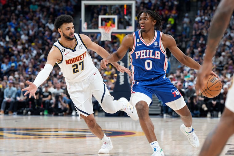 Philadelphia 76ers guard Tyrese Maxey, right, drives to the basket as Denver Nuggets guard Jamal Murray defends.