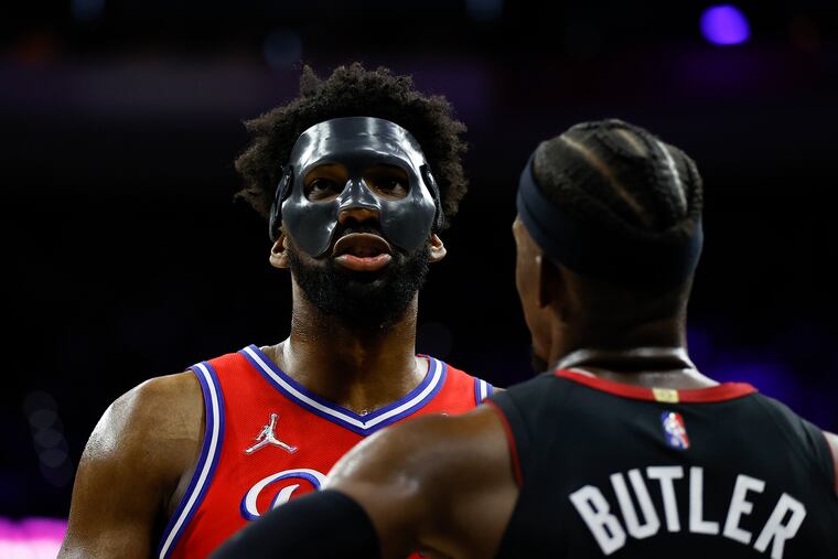 Sixers center Joel Embiid talks to Miami Heat forward Jimmy Butler during Game 4.