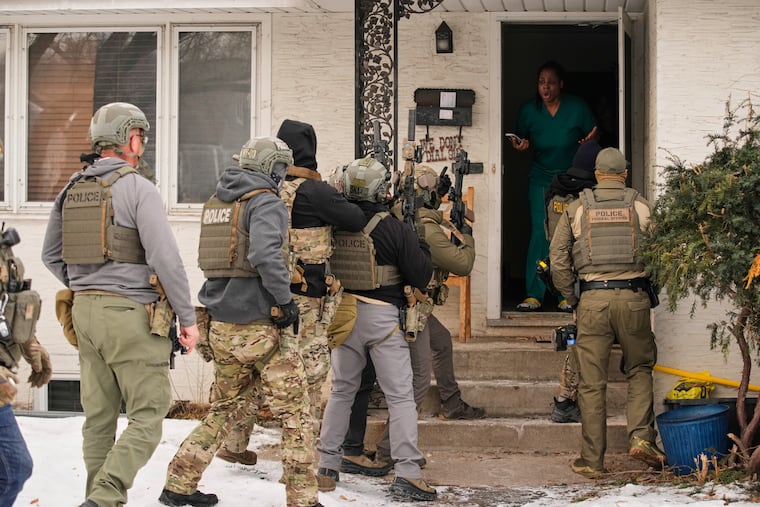 Teyana Gibson Brown, second from right, wife of Garrison Gibson, reacts after a federal immigration officer used a battering ram to break down a door before arresting her husband on Jan. 11. in Minneapolis.