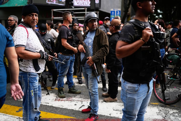 Pro-government armed civilians attend a protest demanding the release of President Nicolas Maduro and first lady Cilia Flores, the day after U.S. forces captured and flew them to the United States, in Caracas, Venezuela, Sunday, Jan. 4, 2026.