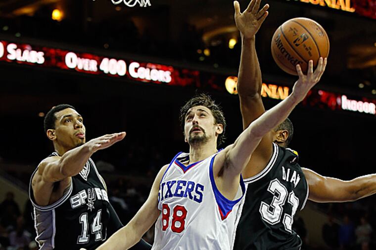 The Sixers' Alexey Shved attempts a shot against the Spurs' Danny Green and Boris Diaw. (Yong Kim/Staff Photographer)