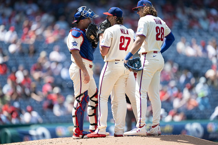 J.T. Realmuto and Alec Bohm gather to talk with Phillies starting pitcher Aaron Nola during the fourth inning against the Cincinnati Reds. Nola allowed four runs on eight hits in five innings on Wednesday.