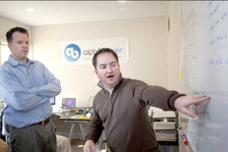 Alphabuyer Inc. chief executive Kevin Johnson watches as company cofounder John Raisch explains a new strategy. (Ed Hille / Staff Photographer)