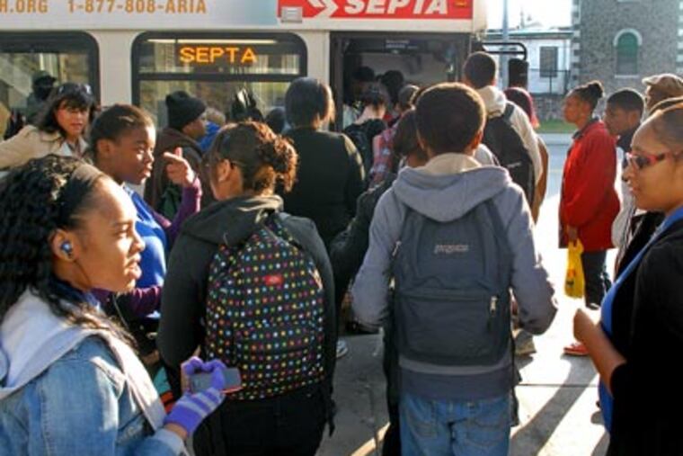 Commuters board SEPTA city division buses at the Frankford Transportation Center this morning. ( Tom Gralish / Staff Photographer )