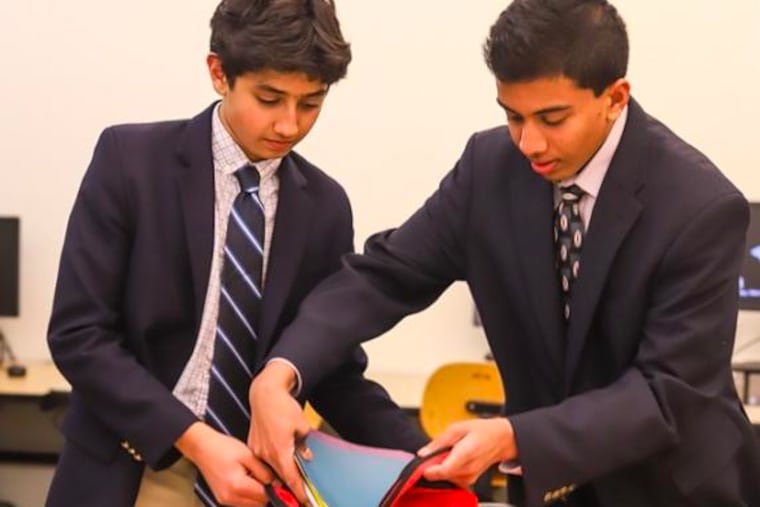 Daniel Adibi (left) and Advaith Kollipara put together a bundle of school supplies to be donated to a refugee student.