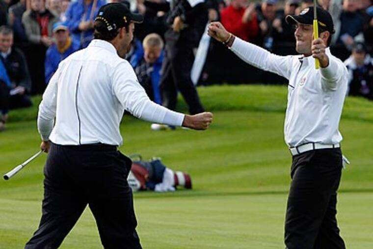 Europe's Francesco, right, and Edoardo Molinari celebrate after securing a half point Sunday at the Ryder Cup. (AP Photo/Jon Super)
