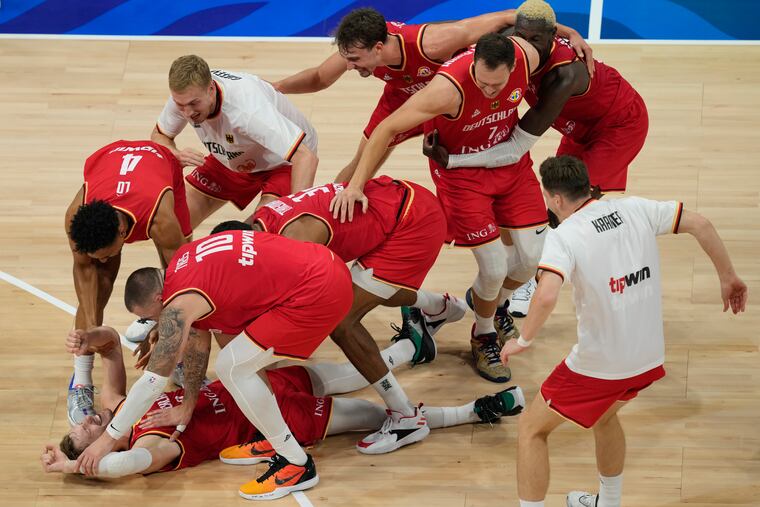 Germany guard Andreas Obst lays on the ground as teammates celebrate after defeating the United States on Friday.