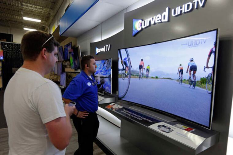 Shopping for a TV at a Best Buy store in Greenwood, Ind. Shown is a Samsung 78-inch curved television. (Michael Conroy / AP)