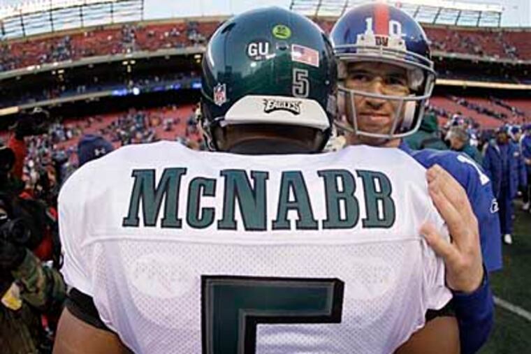 New York Giants quarterback Eli Manning (10) talks with Philadelphia Eagles quarterback Donovan McNabb (5) at the end of the NFL football game Sunday, Dec. 7, 2008, in East Rutherford, N.J. The Eagles won 20-14. (AP Photo/Julie Jacobson)