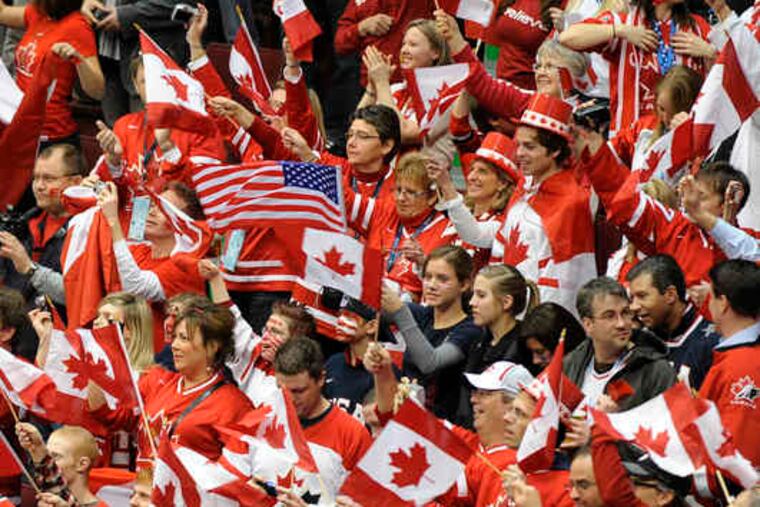 In a sea of Canadian flags and jerseys in the arena, a lone American flag waves during the U.S.-Canada hockey game.