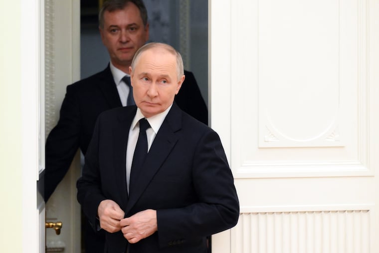Russian President Vladimir Putin (front) enters a hall for his meeting Wednesday with Hungarian Foreign Minister Peter Szijjarto at the Kremlin in Moscow.