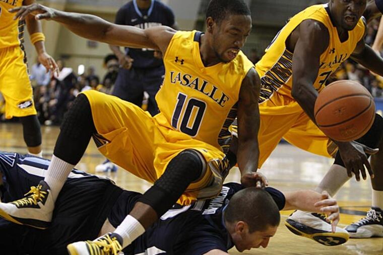 La Salle's Sam Mills falls on Villanova's Ryan Arcidiacono, bottom, as
they chase a loose ball in overtime. LaSalle Explores win 77-74 in
overtime over the Villanova Wildcats at the Gola Arena in Philadelphia
on November 25, 2012. (David Maialetti/Staff Photographer)