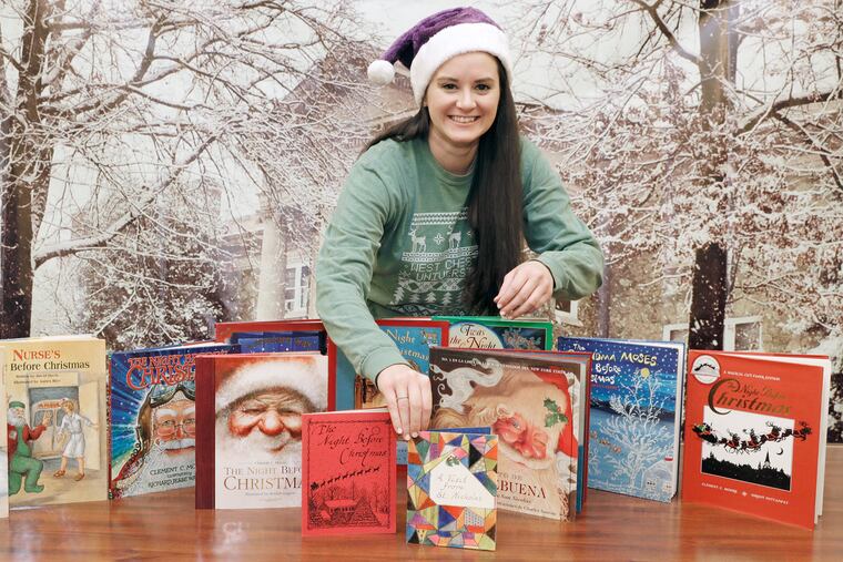 Brigid Gallagher, West Chester University's assistant director of alumni engagement, with the collection of books that were read during the school's virtual holiday storytelling series.