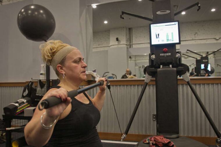 Lisa Stanton, a secretary in the Jefferson department of otolaryngology, works out with the EXOS stability lift bar at the Myrna Brind Center of Integrative Medicine on Chestnut Street.