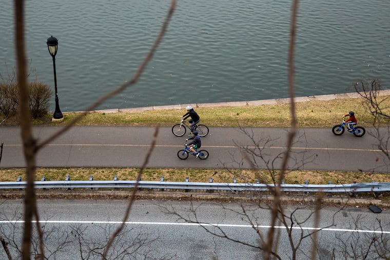 A family on a bike ride along Kelly Drive near the Schuylkill River.