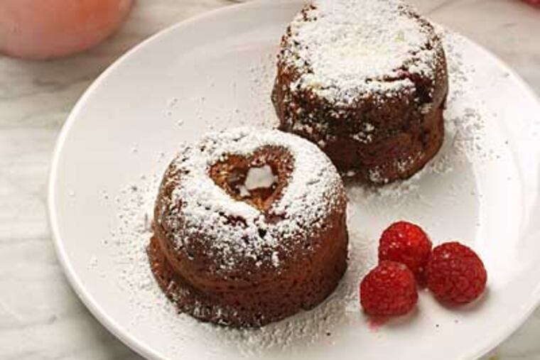 Though dubious about the menu, Adam J. Schiff valiantly tied on an apron and stepped up to the stove. The mini chocolate cakes for dessert are richly addictive. (MICHAEL BRYANT / Staff Photographer)
