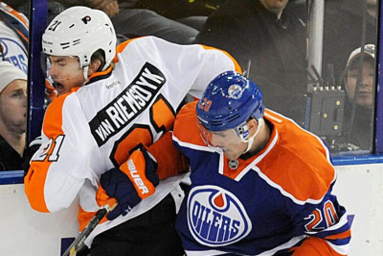 James van Riemsdyk gets checked into the boards by the Oilers' Eric Belanger. (John Ulan/The Canadian Press/AP)