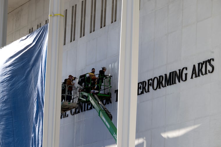Workers add President Donald Trump's name to the Kennedy Center in December.