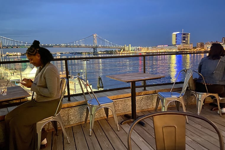 At Liberty Point on Penn's Landing on April 30, 2022, the Ben Franklin Bridge and Camden glow at dusk.