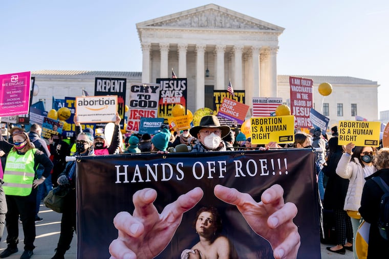 A protester holds a sign that reads "Hands Off Roe!!!" as abortion rights advocates and anti-abortion protesters demonstrate in front of the U.S. Supreme Court, Wednesday, Dec. 1, 2021, in Washington. The court's dismantling of Roe is one of the decisions that has angered liberals.