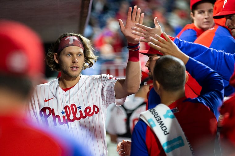 Alec Bohm, left, of the Phillies is congratulated in the dugout after driving in the winning runs in the 8th inning against the Brewers on April 22, 2022.