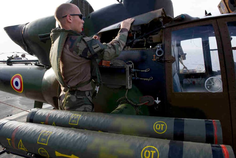A pilot checks a combat helicopter on the deck of the French navy vessel BPC Tonnerre in the Mediterranean.British Apache and French attack helicopters struck targets for the first time in NATO's campaign in Libya.