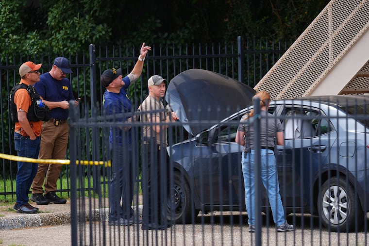 Law enforcement agents search a vehicle near the scene of a shooting at a U.S. Immigration and Customs Enforcement office in Dallas on Wednesday, Sept. 24.