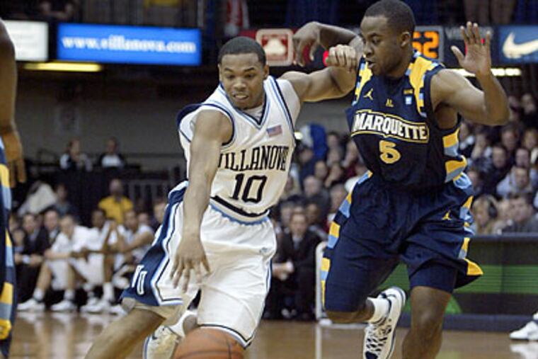 Marquette's Junior Cadougan defends as Corey Fisher drives the ball into the lane during the first half. (H. Rumph Jr/AP)