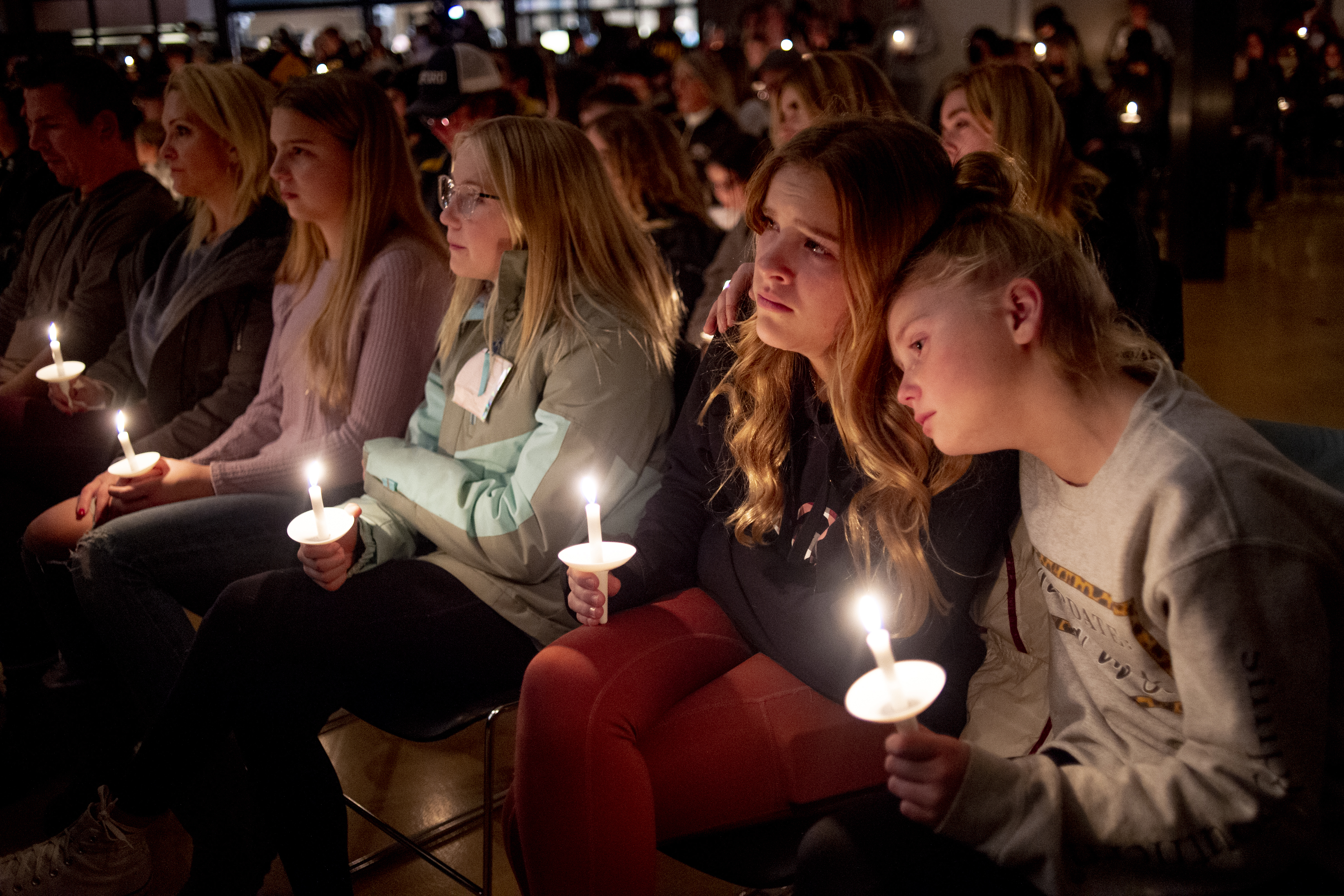 Emerson Miller, right, leans on her friend Joselyn's shoulder as they listen to Jessi Holt, pastor at LakePoint Community Church, during a prayer vigil at the church after the Oxford High School school shooting Tuesday in Oxford, Mich.