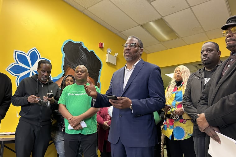 The Rev. Gregory Holston (center), of the 57+ Blocks Coalition and the Philadelphia District Attorney's Office, speaks at a news conference criticizing an Inquirer investigation into anti-violence spending.