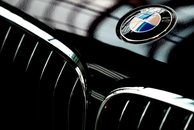 FILE- In this March 21, 2018, file photo, the logo of German car manufacturer BMW is pictured on a BMW 7 in Munich, Germany. BMW AG and Daimler AG will offer cars capable of navigating on highways by themselves starting in 2024, as the luxury-car rivals cooperate to speed up the development of autonomous vehicles.