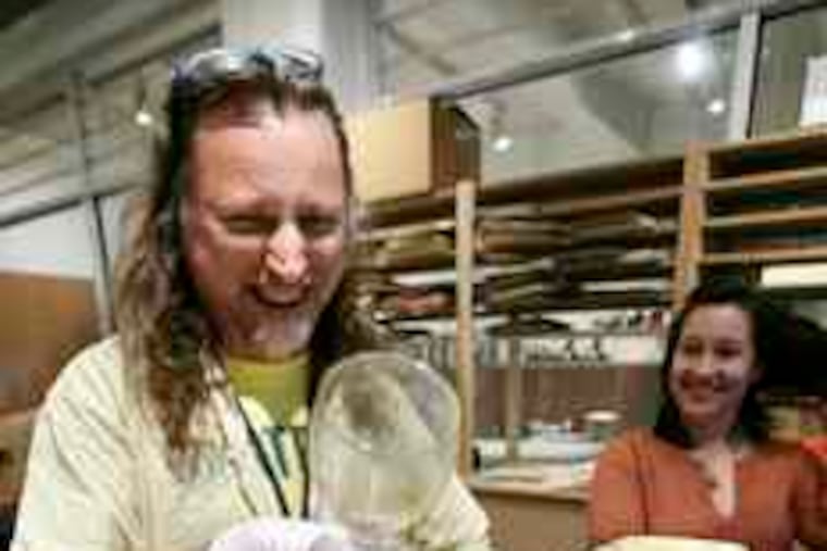 Archivist Matt Wrbican (left), overseeing the project at the Andy Warhol Museum, Pittsburgh, finds a glass. Liz Scott observes.