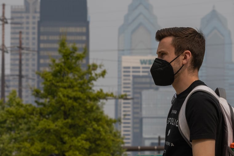 A pedestrian seen wearing a mask along Market Street in Philadelphia earlier this month. The city's air quality reached "unhealthy" levels for sensitive groups, including children and the elderly, on Wednesday.