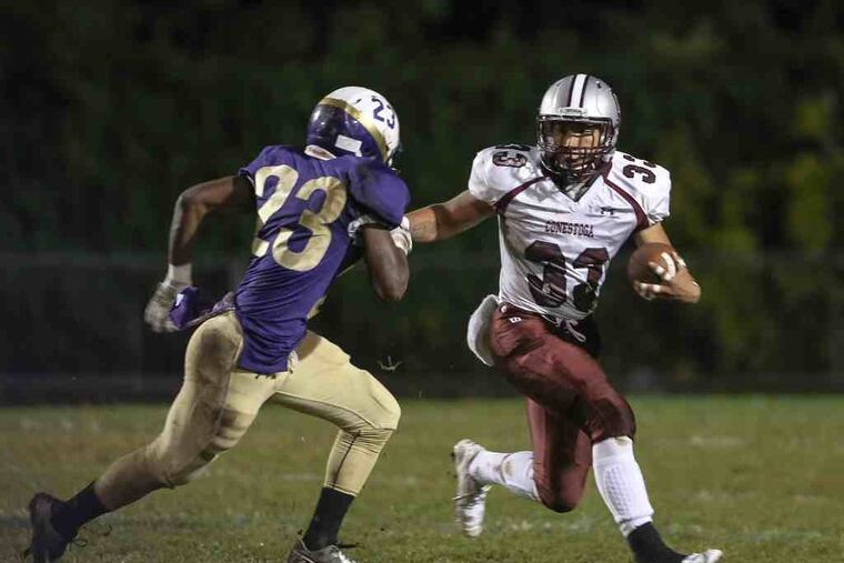 Conestoga's Corey Manning on his 9 yard run against Upper Darby's Naiquan McKenzie during the 1st quarter in Upper Darby, Friday, October 9, 2015.